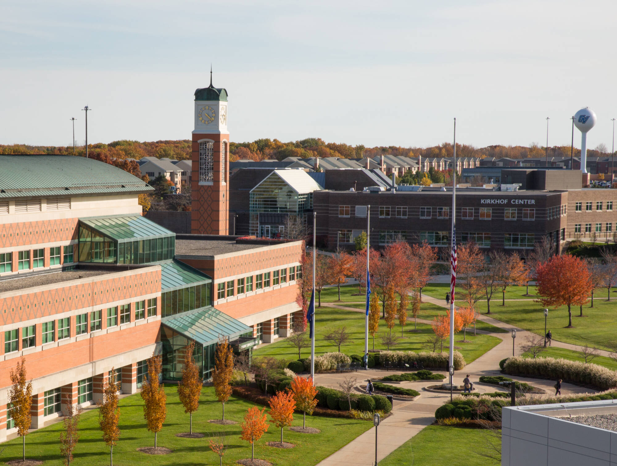 Brick buildings on a college campus with a clock tower and autumn trees.